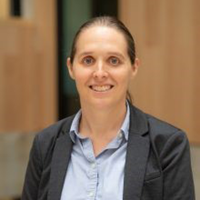 Photo of Professor Amy Bilton wearing navy blazer and blue shirt