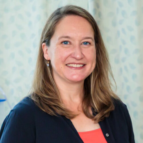 Photo of Professor Robyn Stremler, wearing a navy sweater and orange top